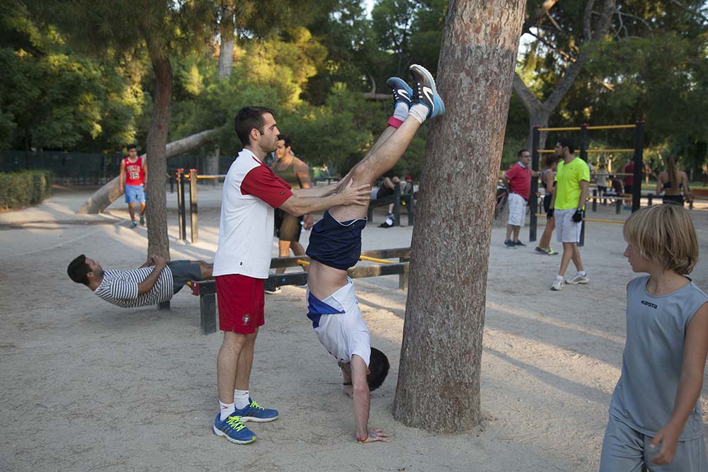  Jóvenes haciendo ejercicios de gimnasia en el Parque del Retiro. foto: santi burgos